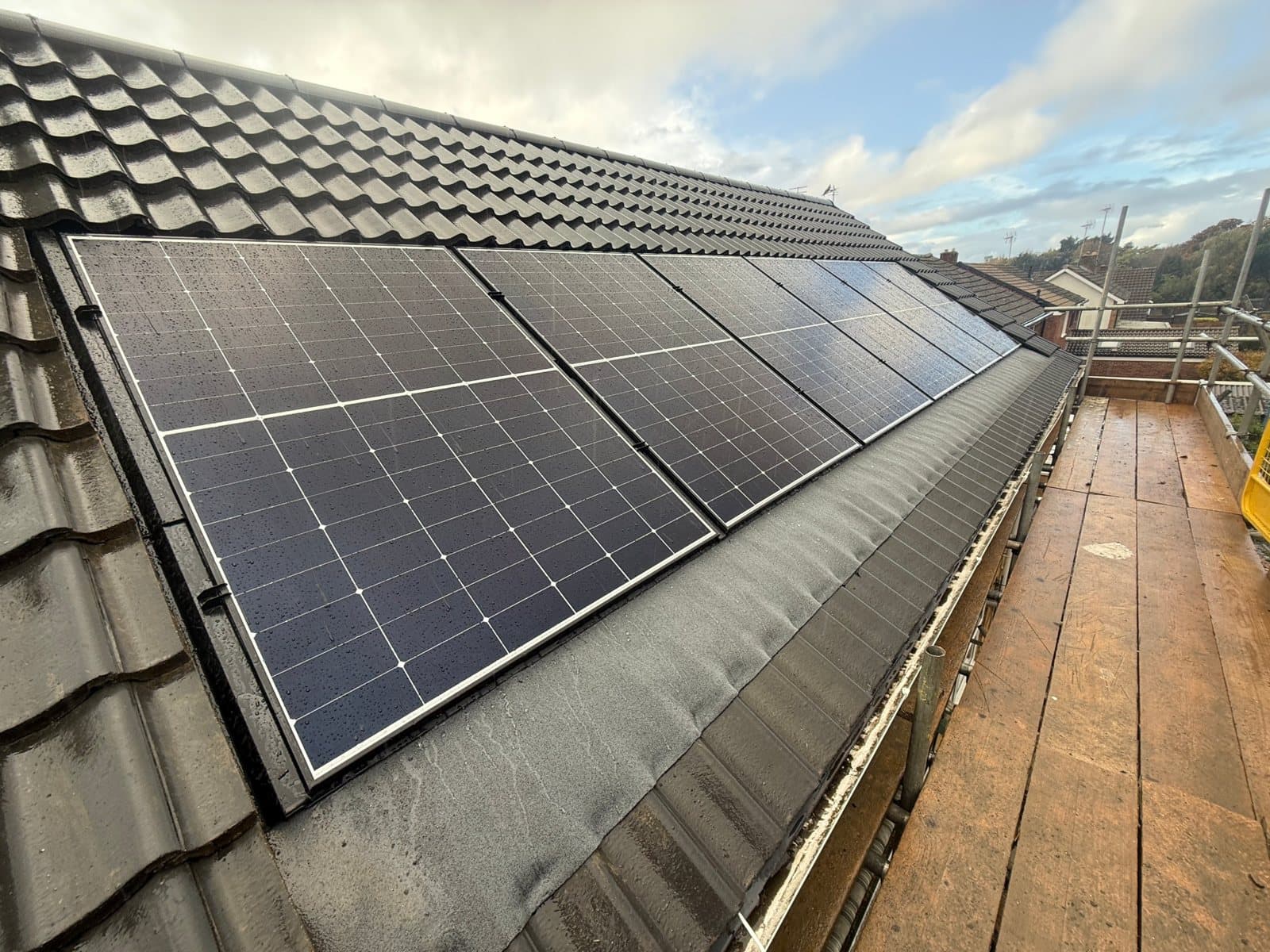 All-black solar panels neatly fitted on a tiled home roof