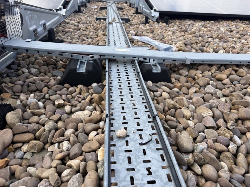 Cables run outside the tray, with debris left behind.