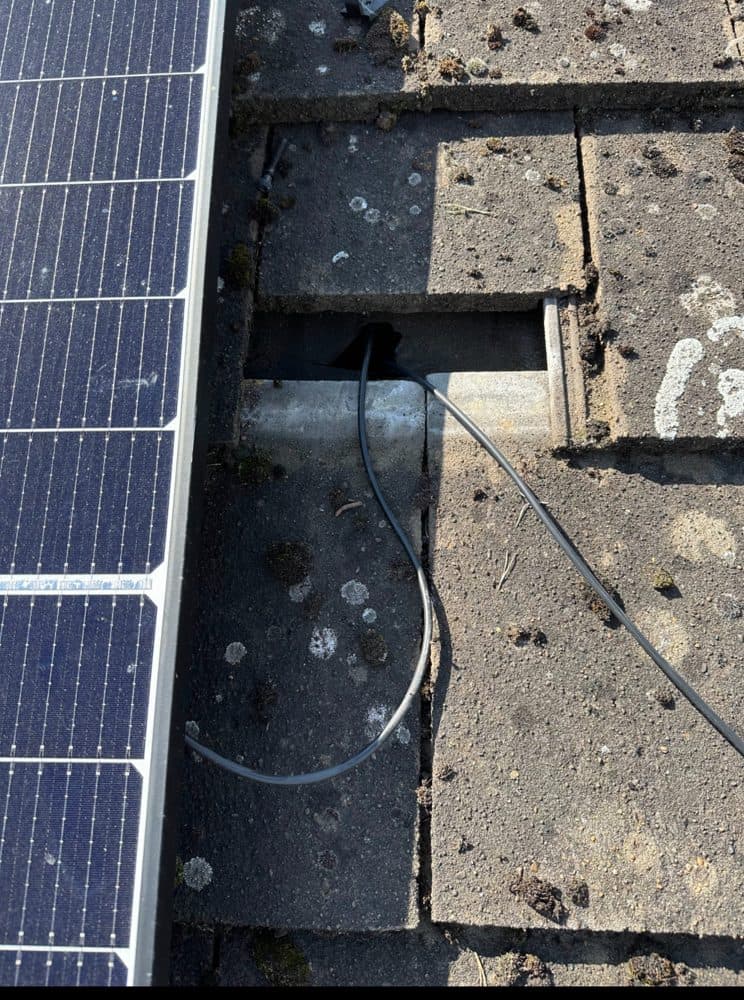 DC cable entry through a cut tile, left open to the weather.