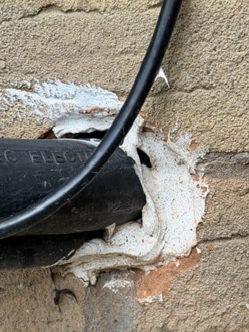 Wall penetration packed with foam, not properly sealed.