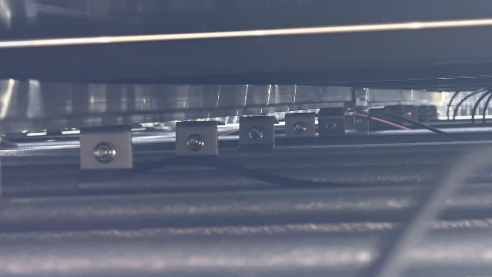 Module clamps and cabling checked beneath the array.