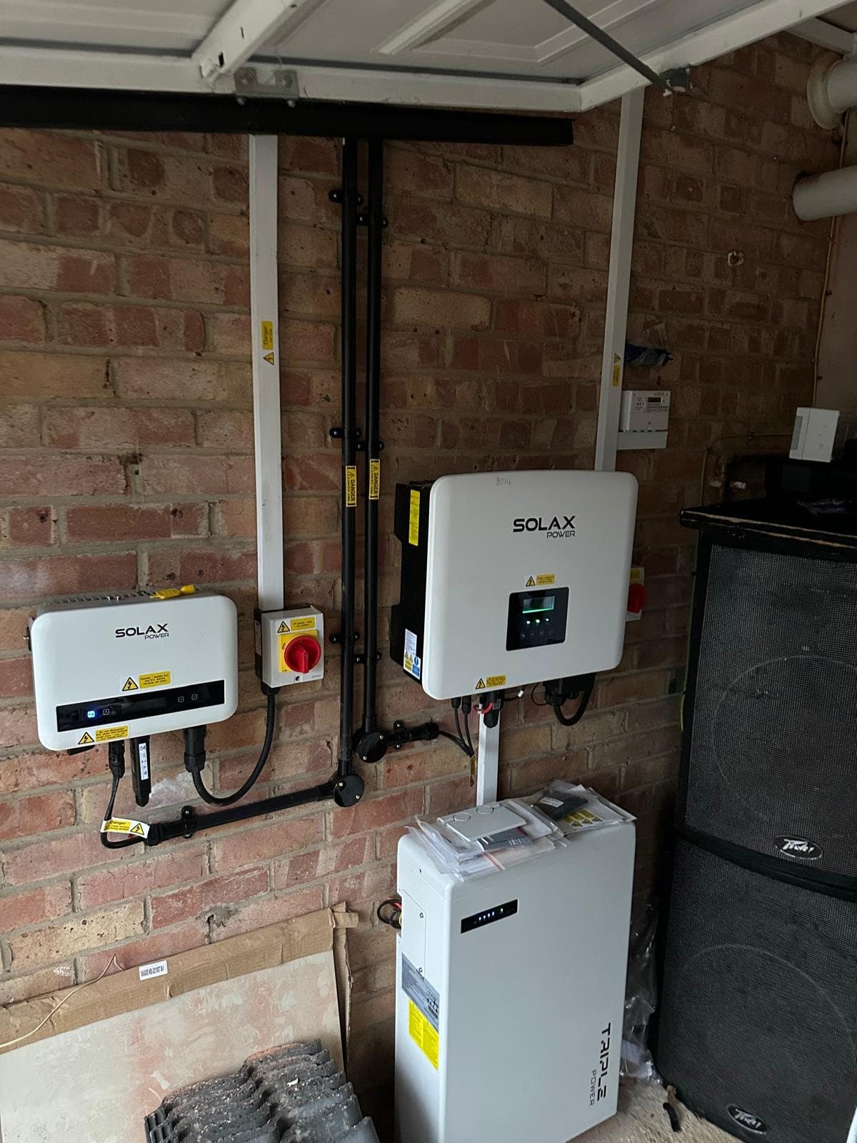 SolaX inverters and a battery neatly installed in a garage